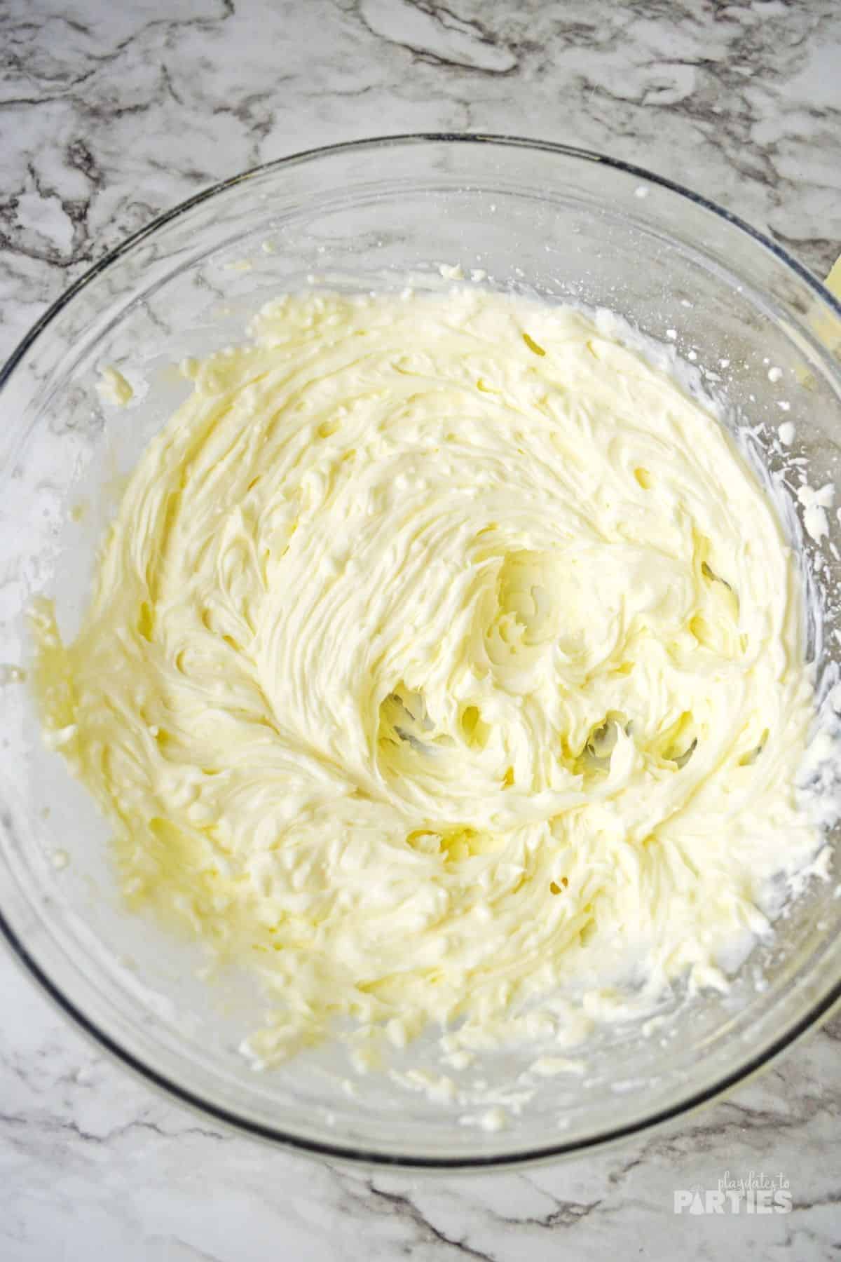 Fluffy cheesecake filling is made by mixing cream cheese, yogurt, lemon, powdered sugar, and cream.