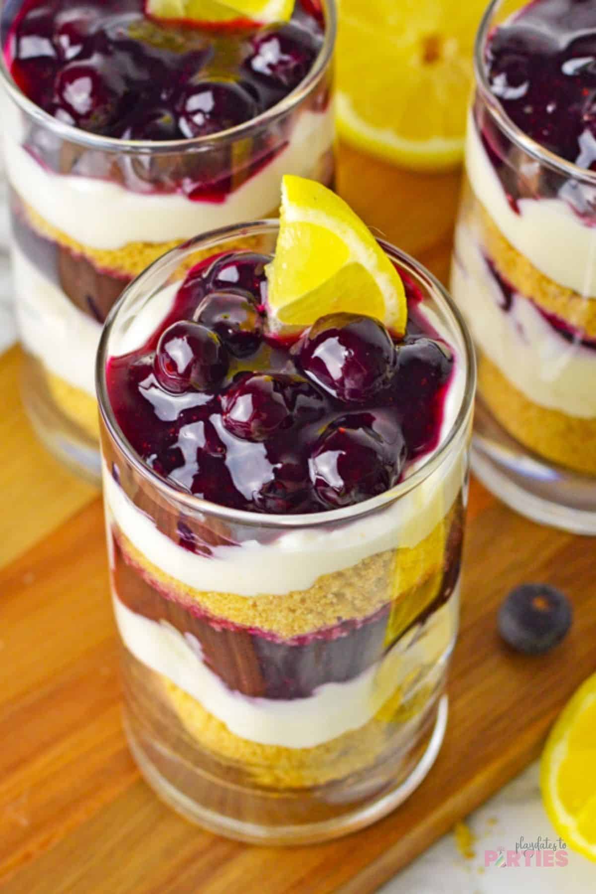 Looking down at the top of a parfait with luscious blueberry sauce garnished with a lemon wedge.