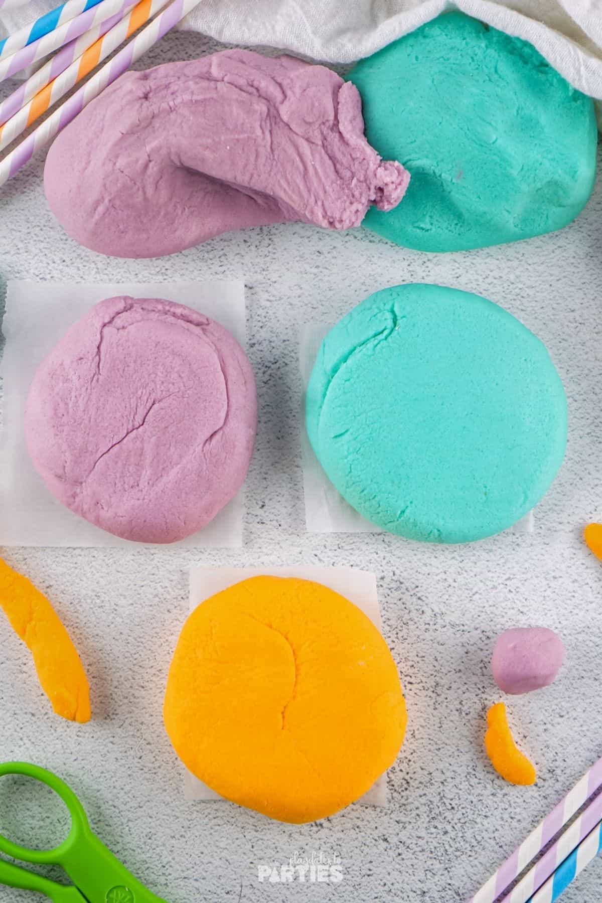 Purple, teal, and yellow homemade playdough without cream of tartar.
