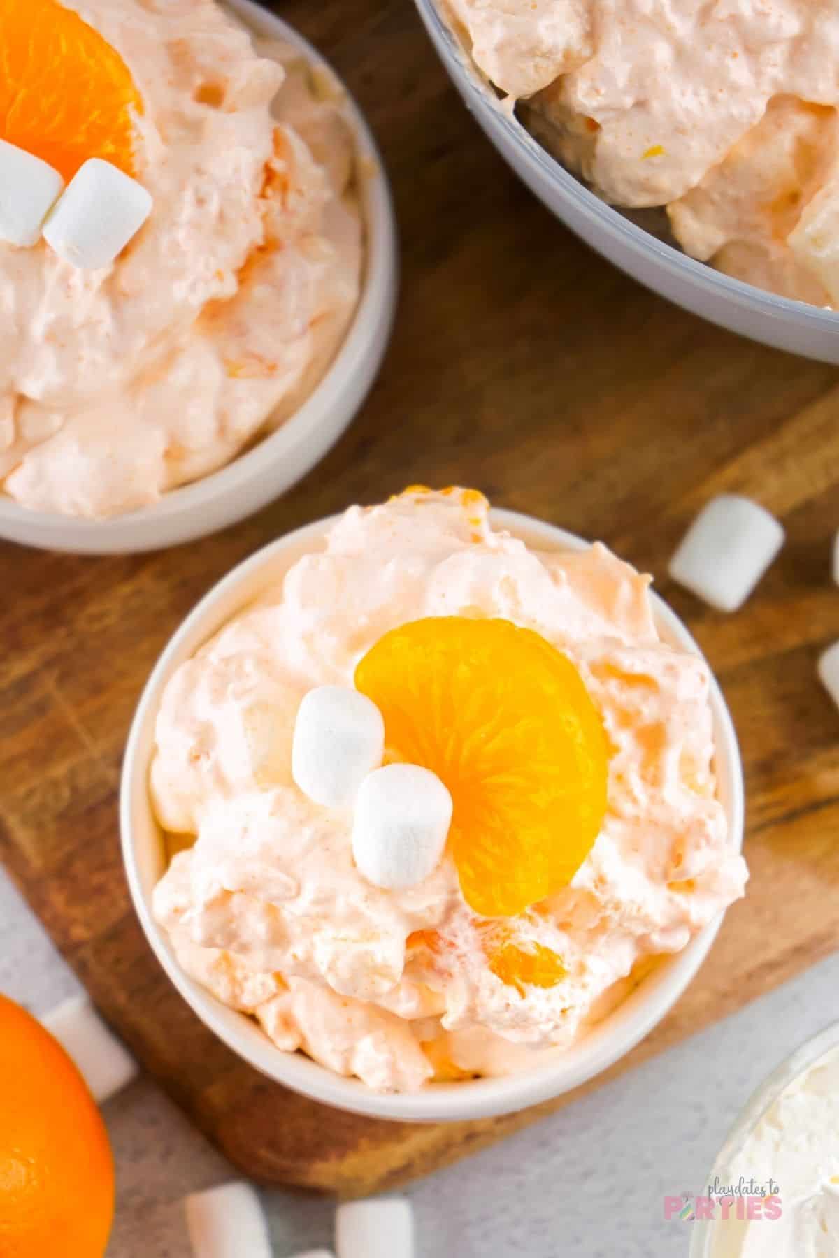 Top view of orange creamsicle fluff topped with mandarins and mini marshmallows.