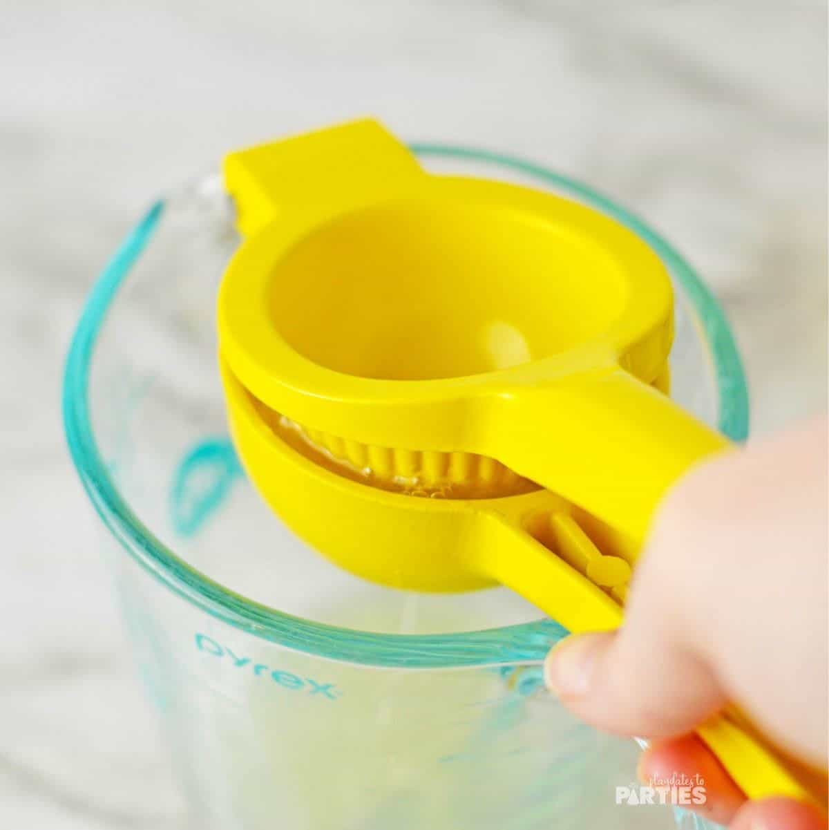 Using a citrus juicer over a liquid measuring cup.