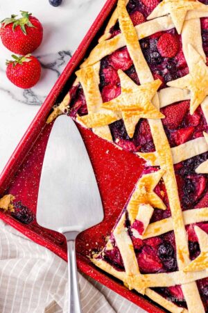 A berry slab pie with a slice cut out.