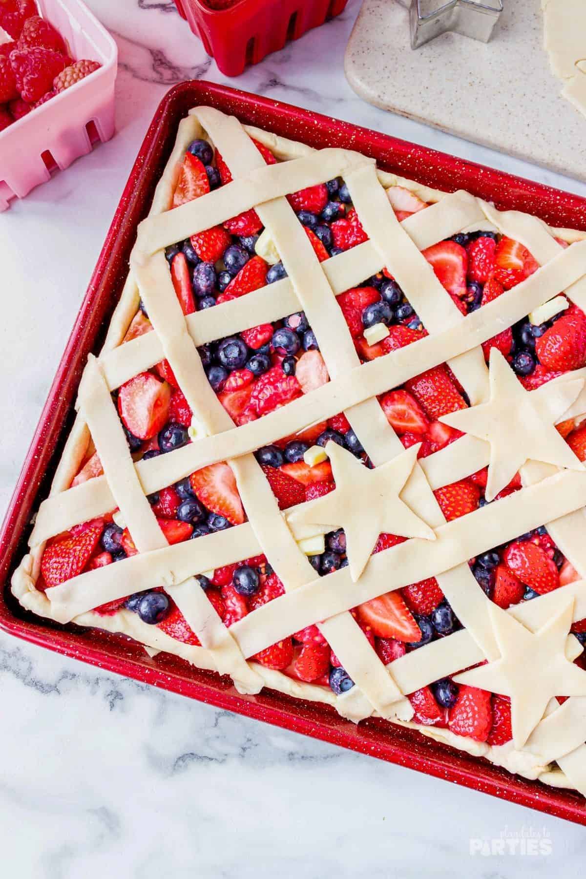 A sheet pan berry pie is ready to go in the oven.