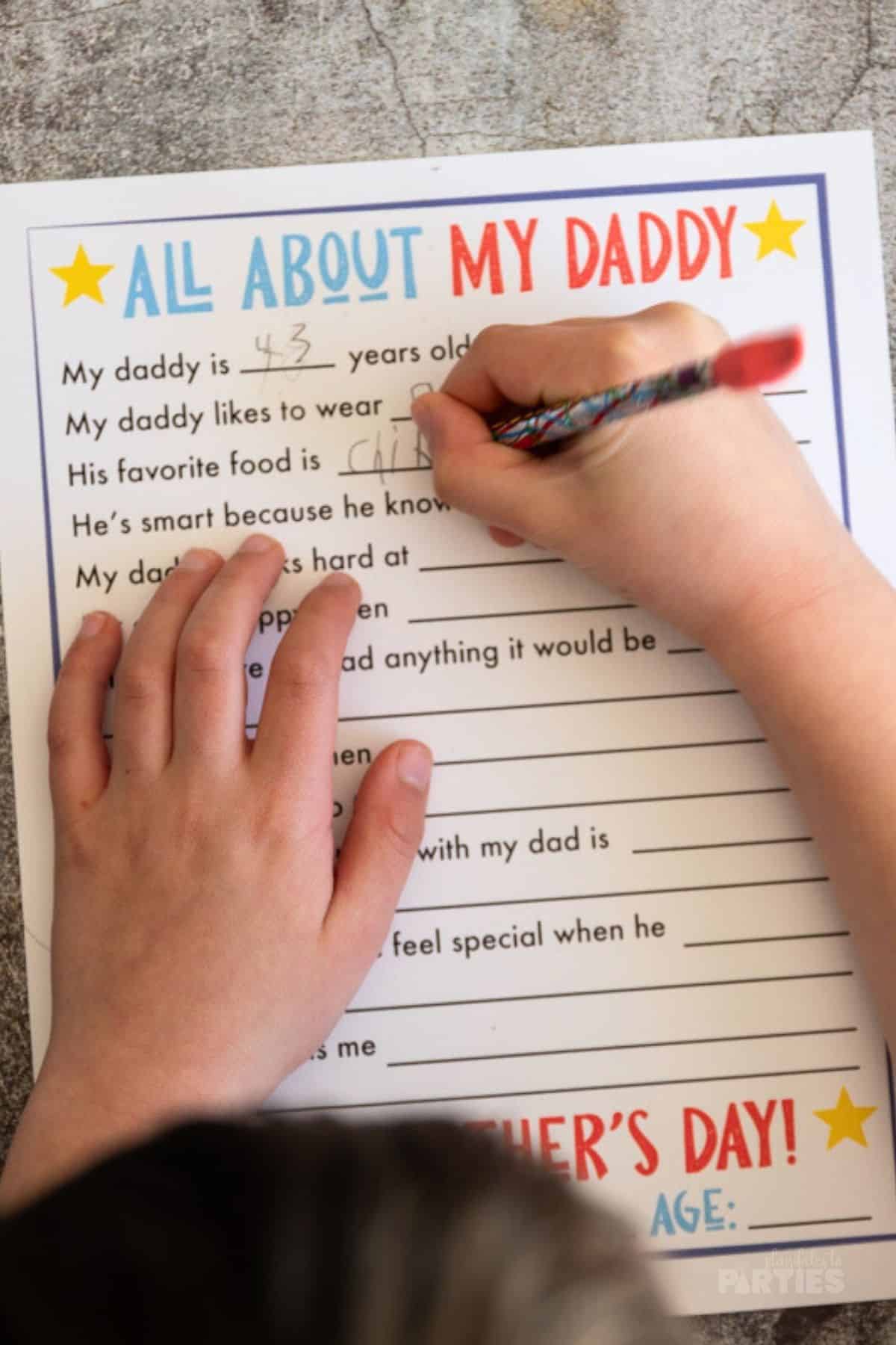 A young boy filling out an all about my daddy questionnaire.