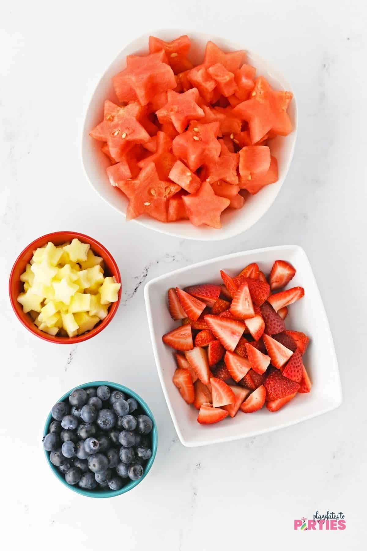 Patriotic ingredients include watermelon, apple stars, blueberries, and sliced strawberries.