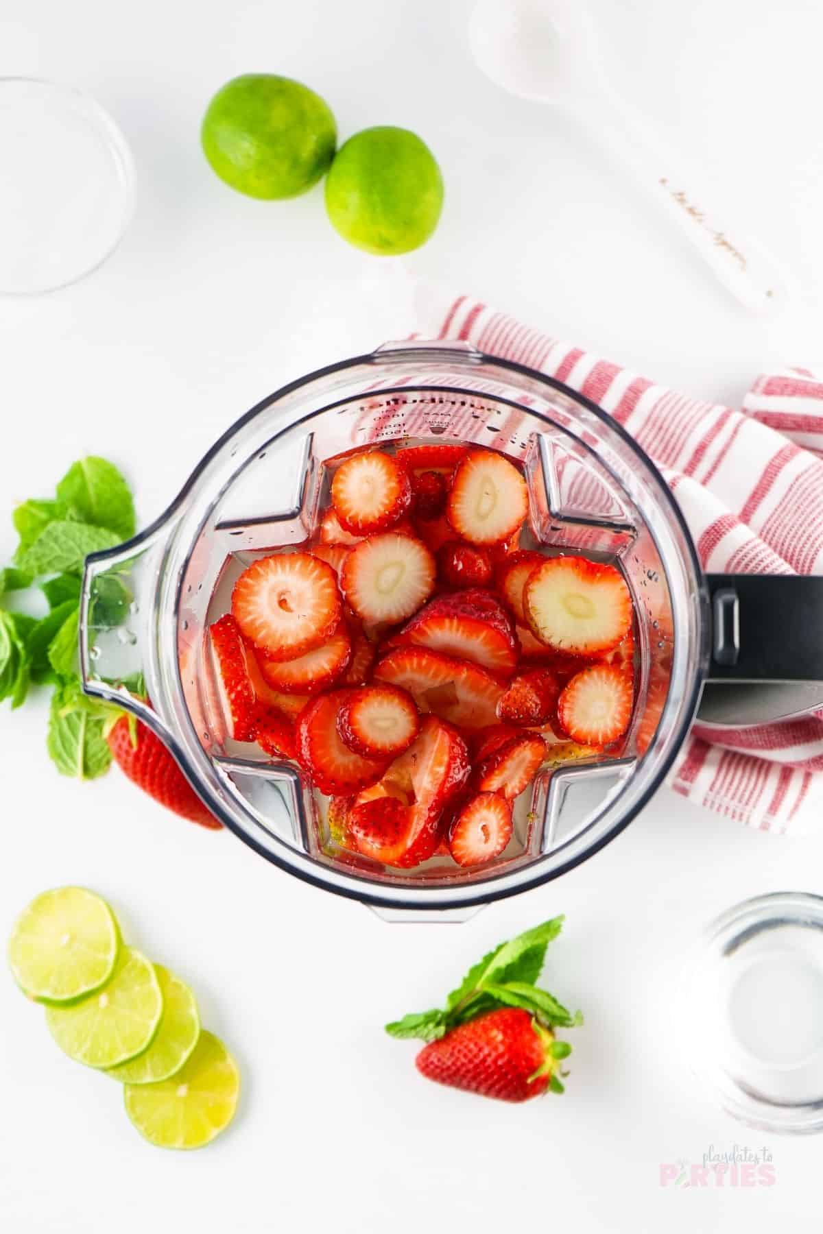 Strawberries and water in a blender.