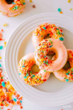 Fruity Pebbles donuts with pink glaze on a plate.