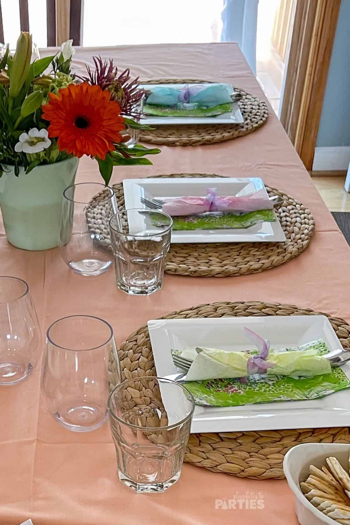 A spring dinner table decorated with fresh flowers and pastel colors.
