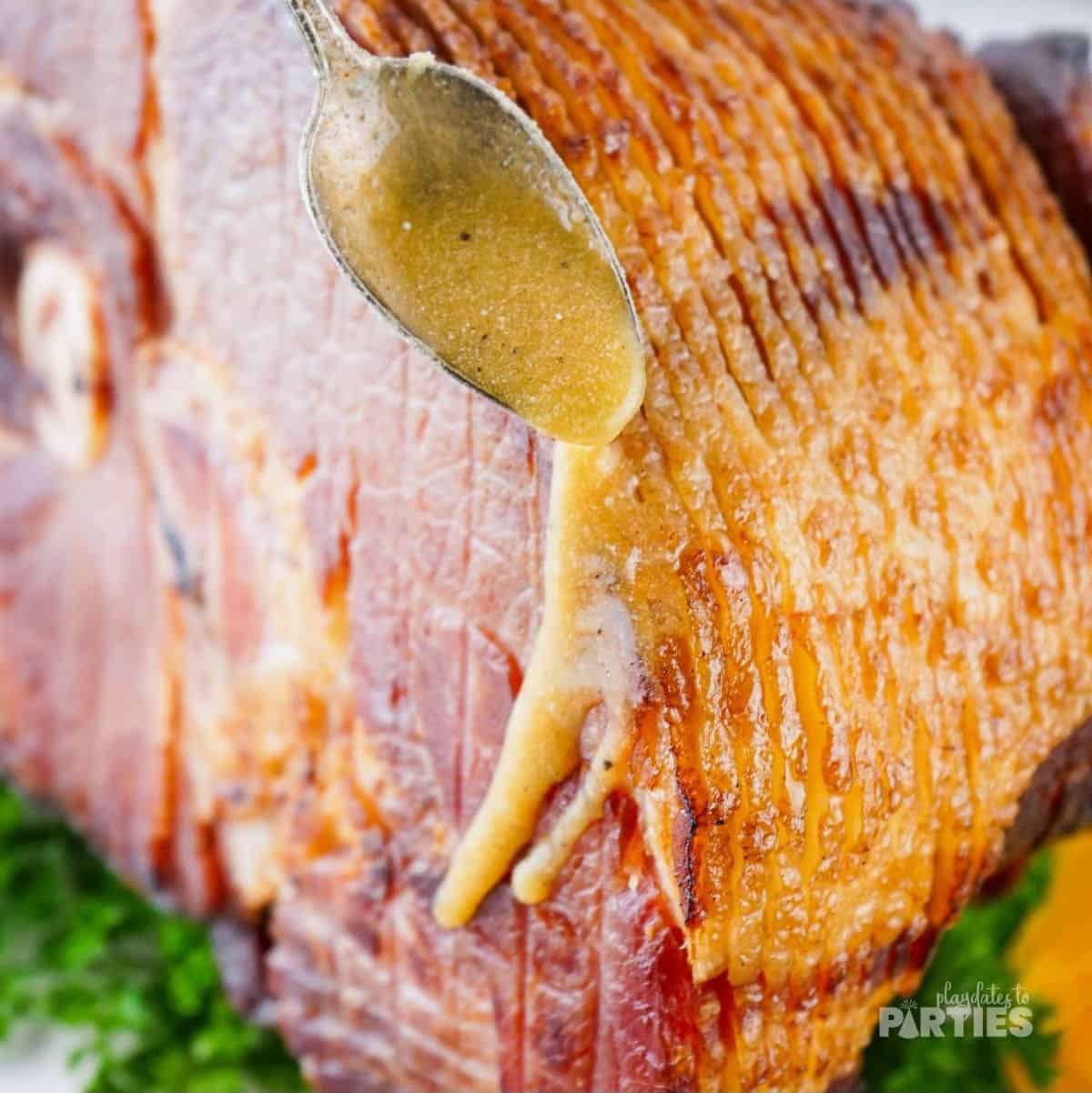 Drizzling glaze down the glaze of a cooked ham.