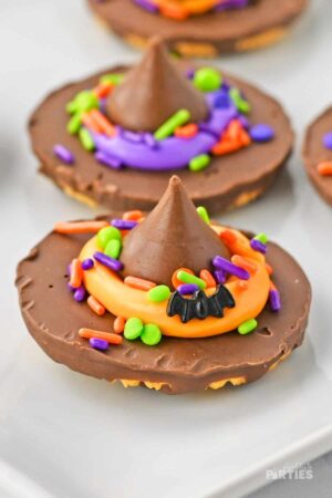 Finished witch hat cookies on a white plate.