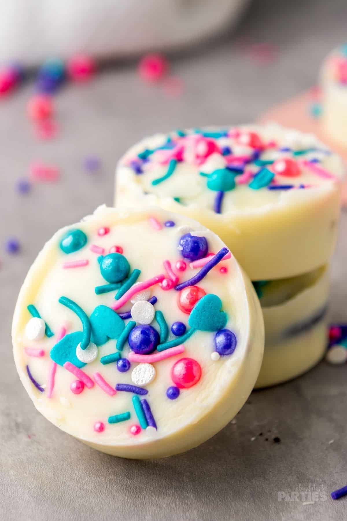Colorful sprinkles shine brightly against white chocolate.