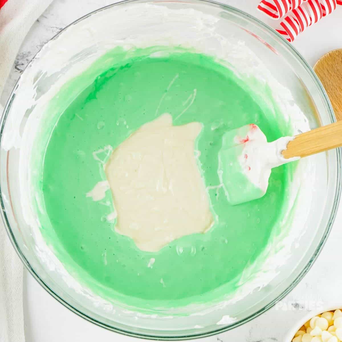 Green colored marshmallow mixture and melted white chocolate chips.