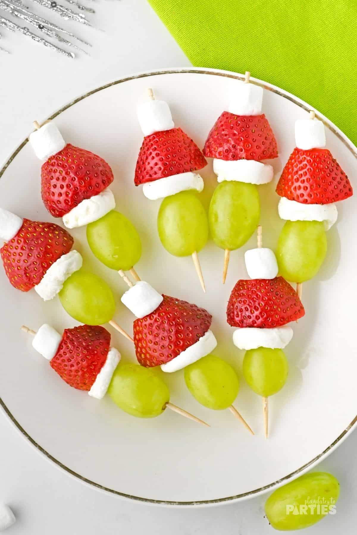 Green grapes with Santa hats made from marshmallows and strawberries.