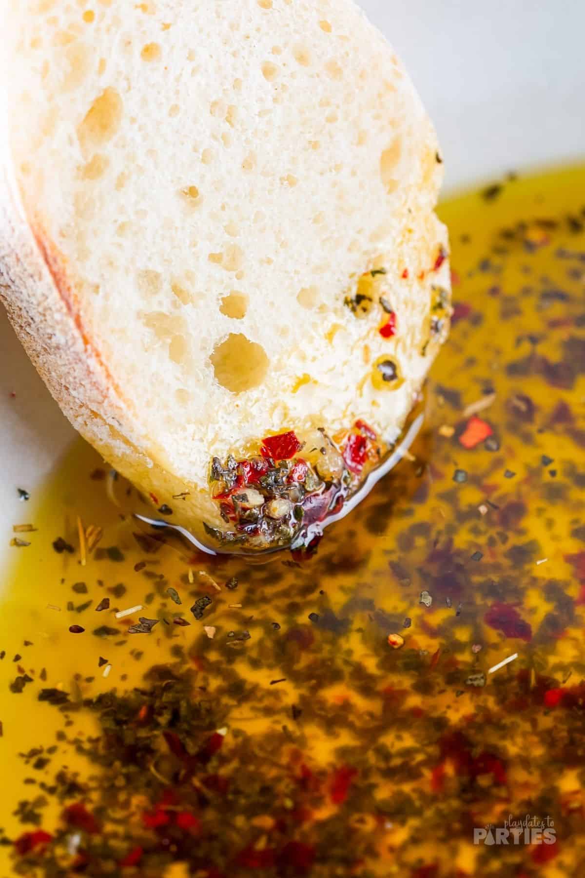 A slice of bread resting in a bowl with dipping oil.