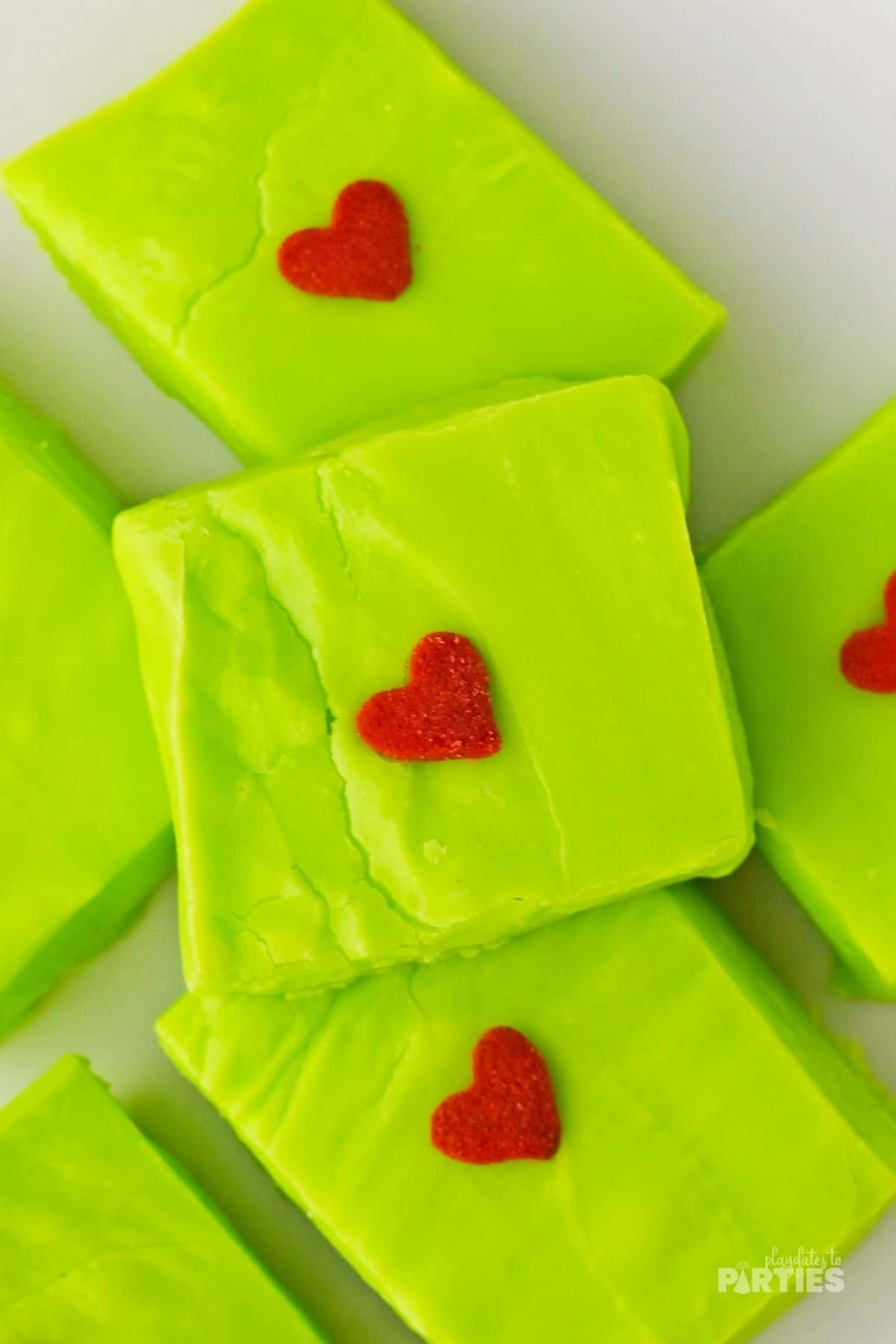 A square of green Grinch fudge with a single candy heart.