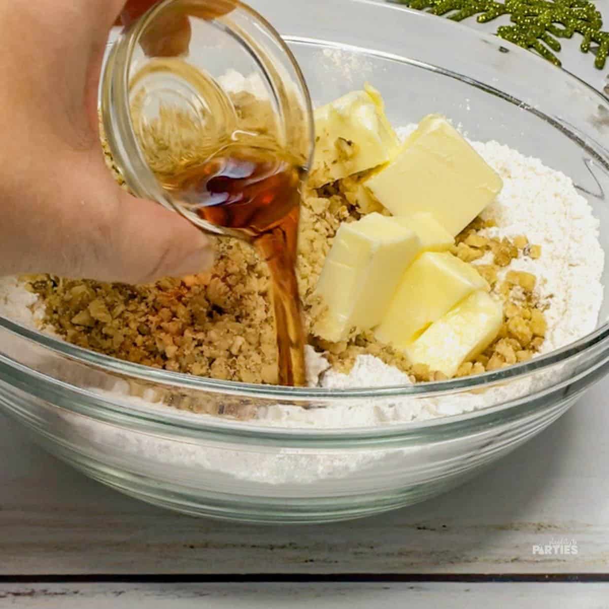 Combining sugar, walnuts, butter, and extract.
