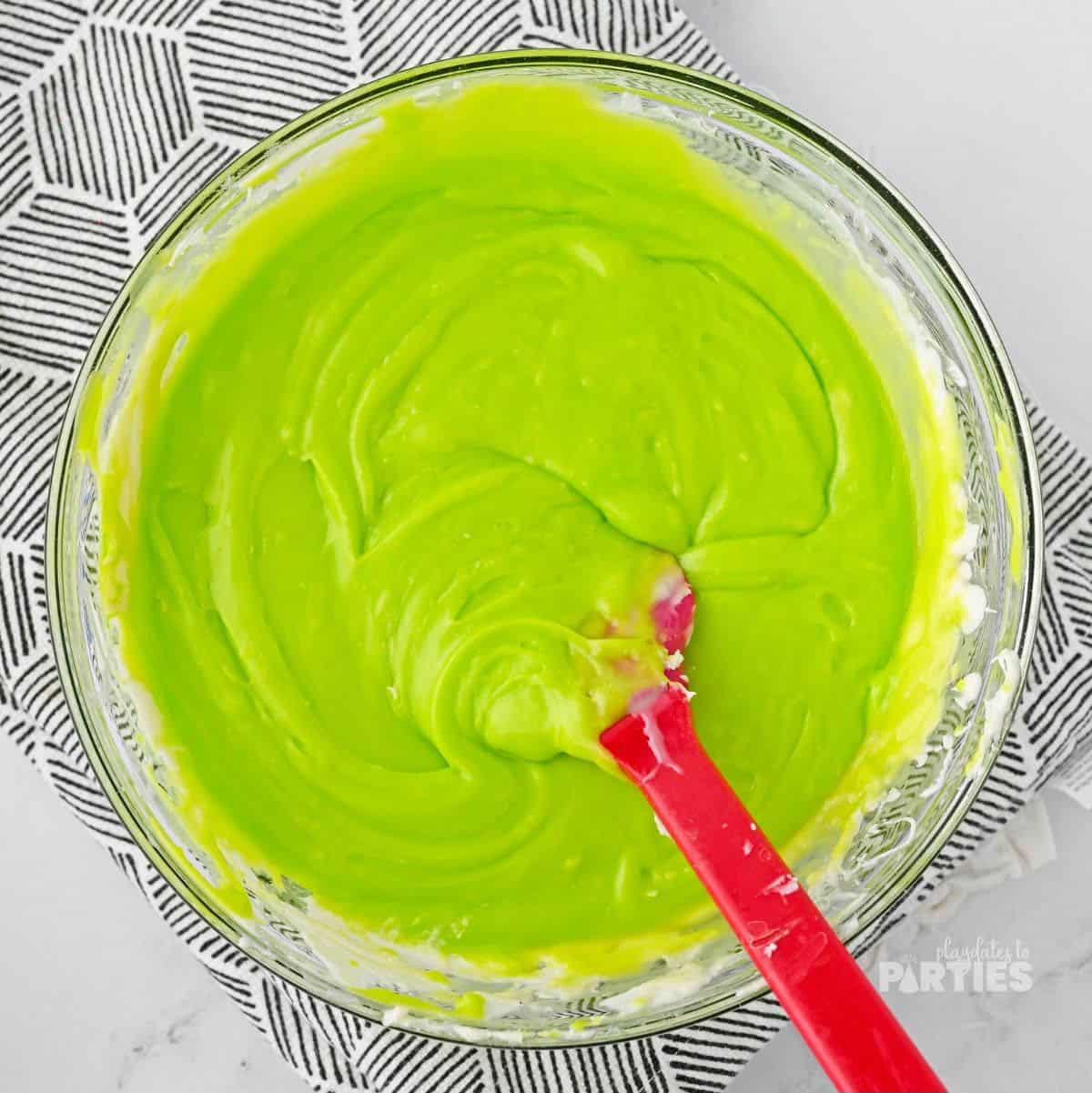 Melted chocolate and condensed milk are tinted a bright green hue.