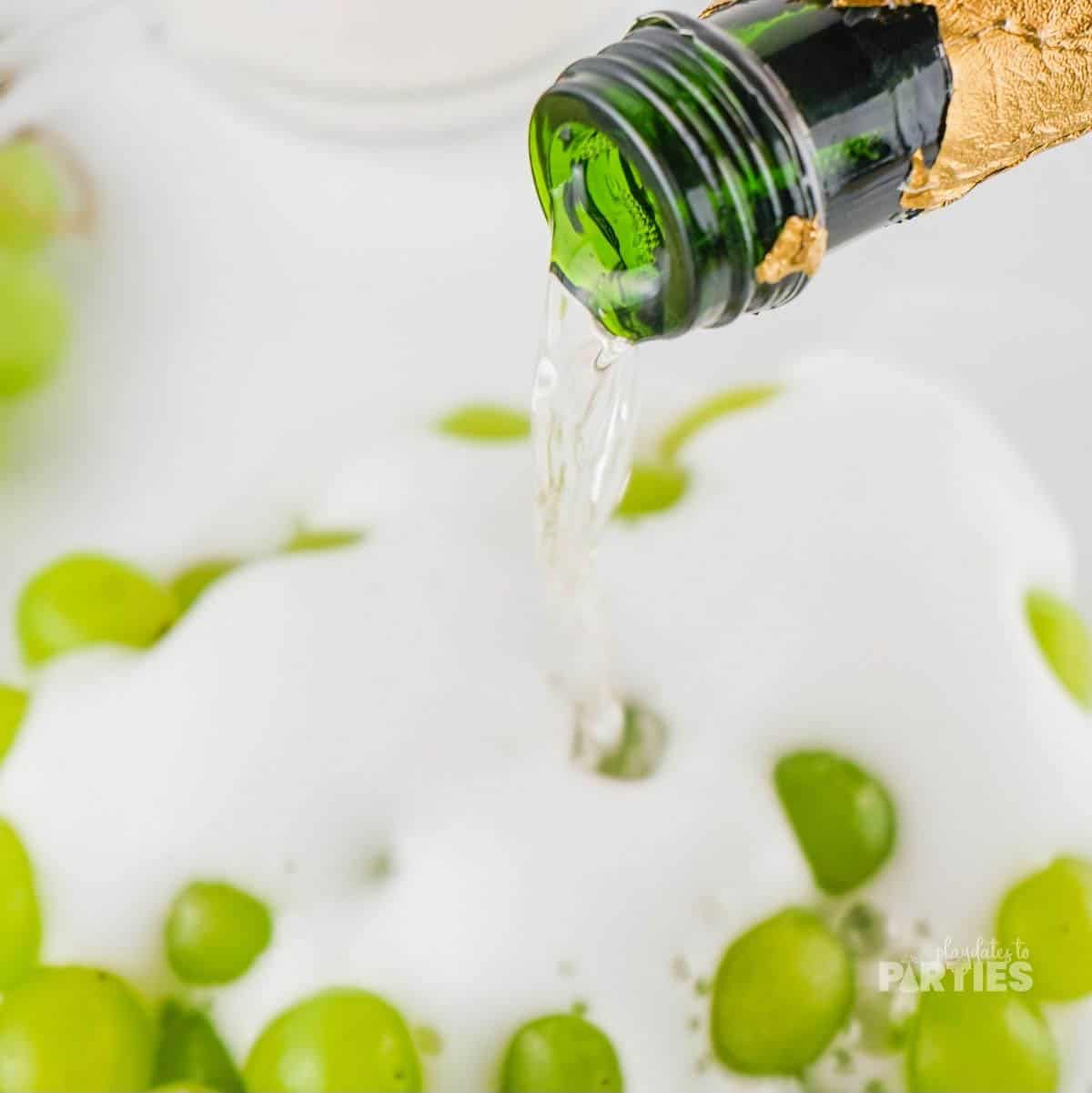 Pouring champagne over green grapes.
