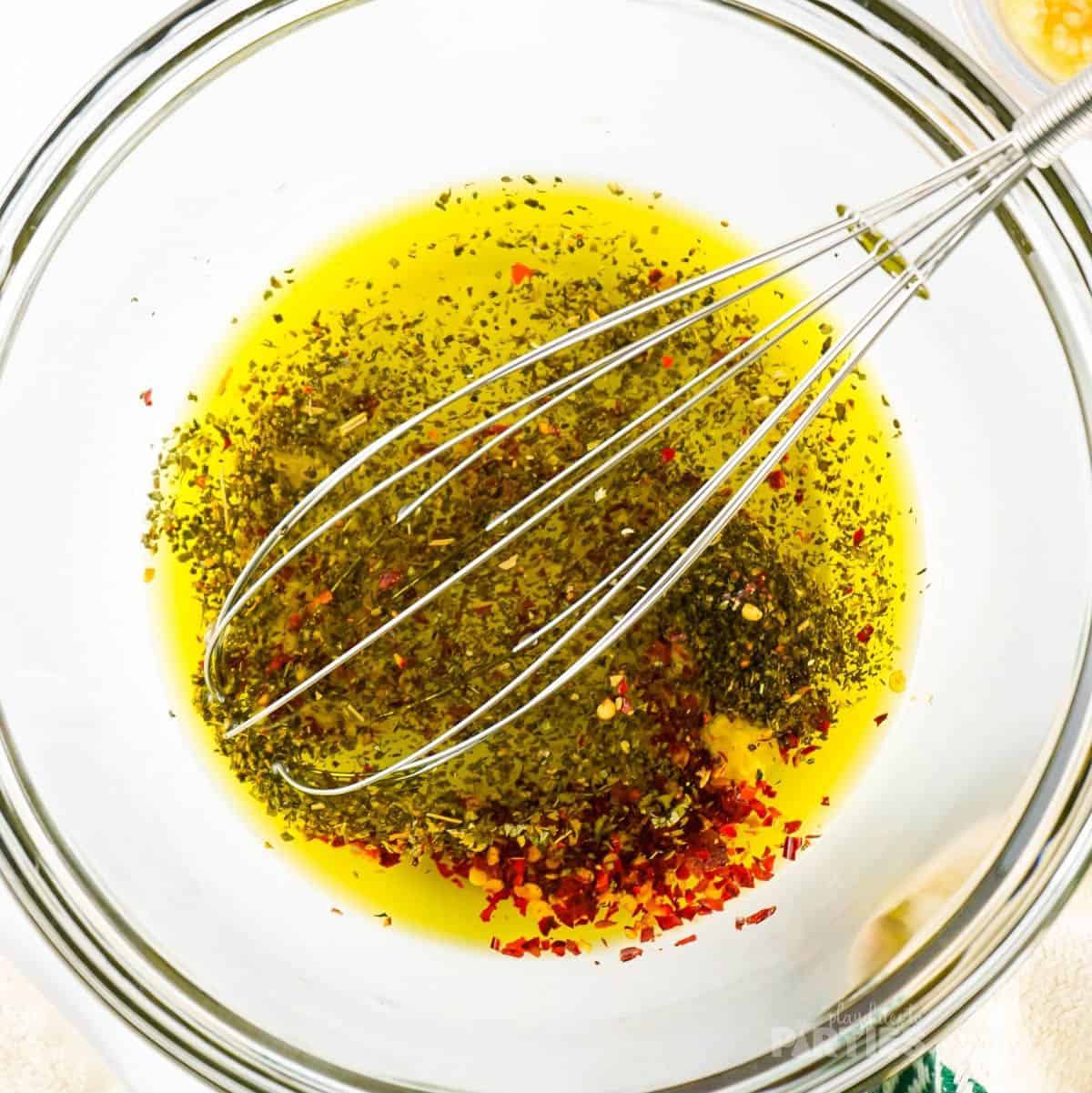 Whisking herbs and olive oil.
