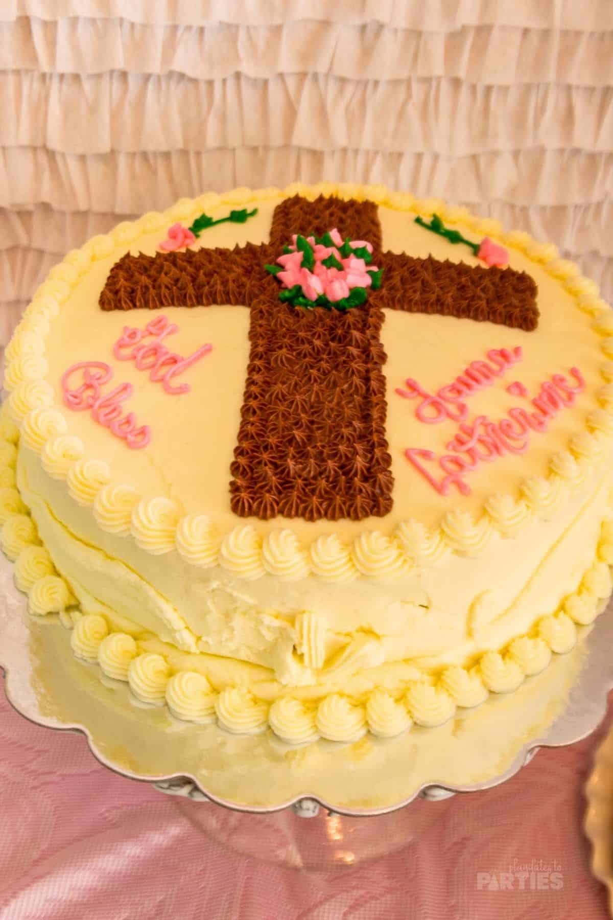 A round cake decorated with a butterceam cross.