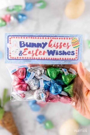 A woman's hand holding an Easter Treat Bag with a Printable topper.