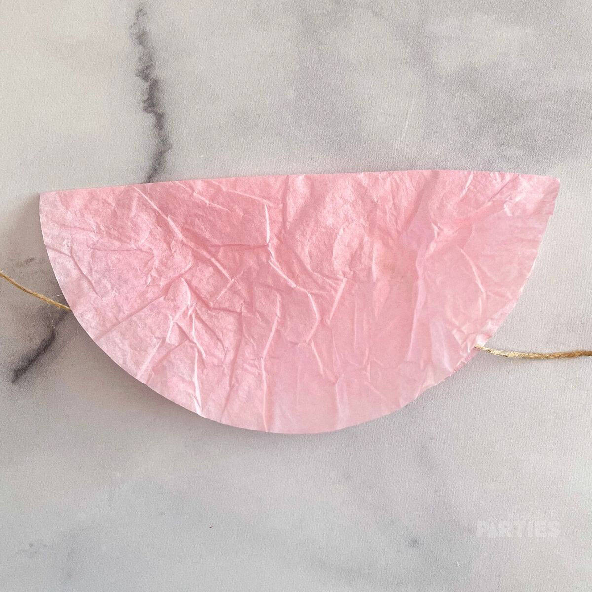 A pink coffee filter folded in half.