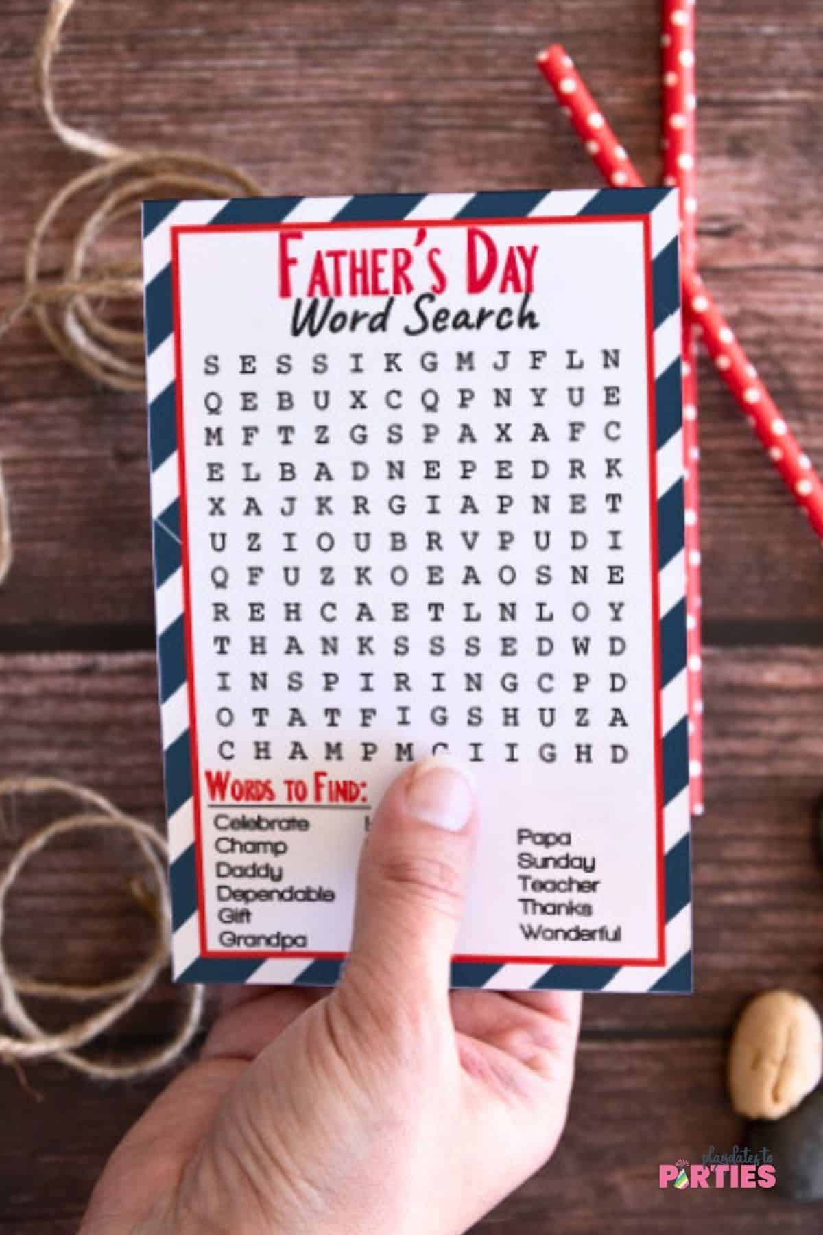 A woman's hand holding a word search puzzle card.