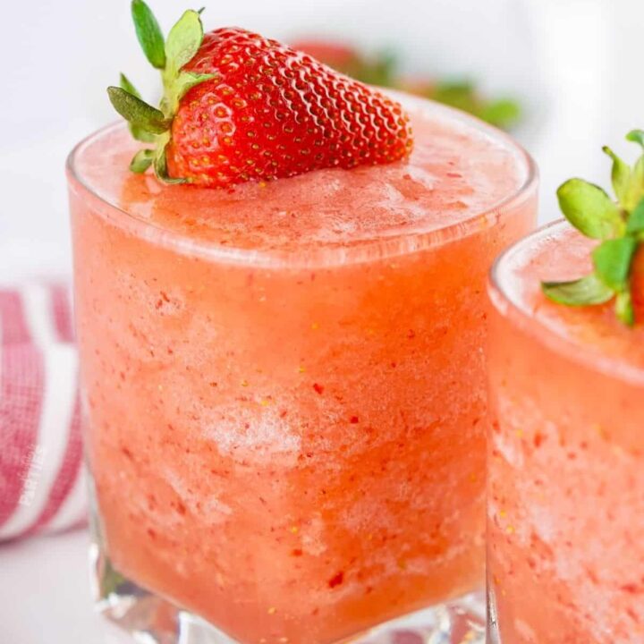 A virgin strawberry daiquiri topped with a fresh strawberry.