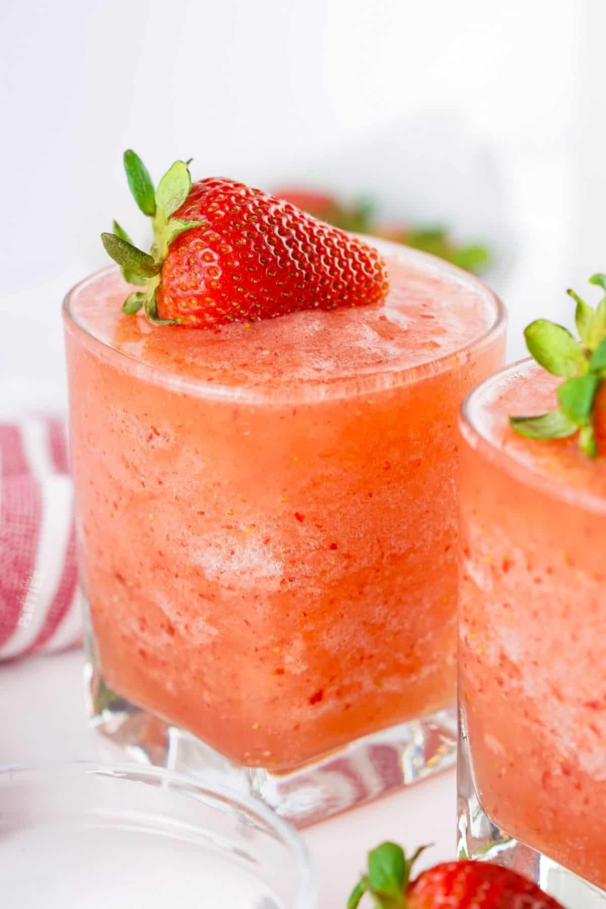 A virgin strawberry daiquiri topped with a fresh strawberry.