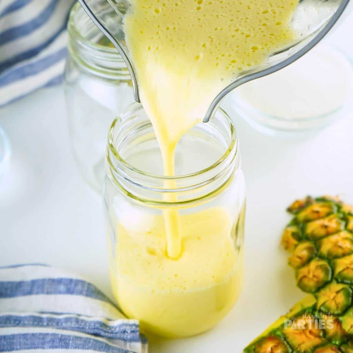Pouring pineapple agua fresca into a drinking glass.