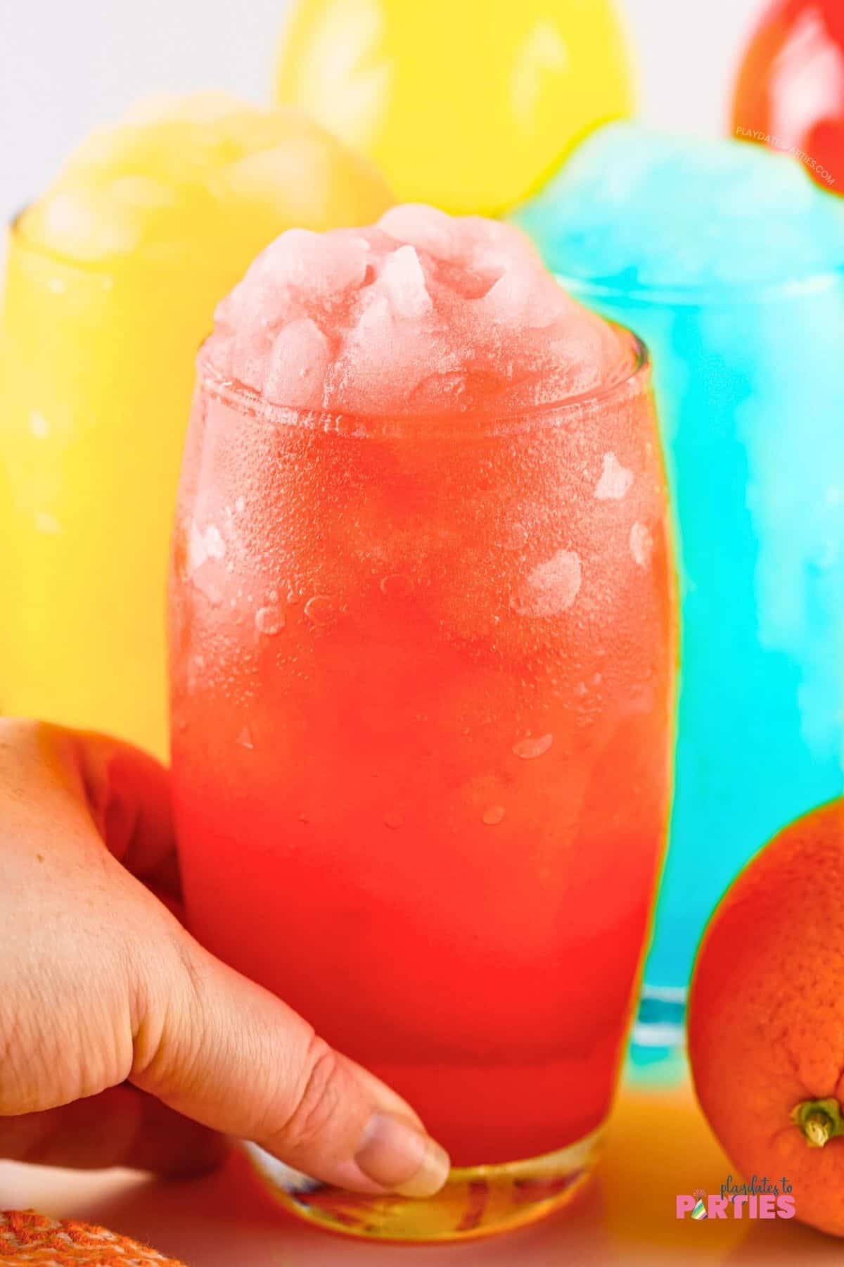 A woman's hand holding a red Gatorade slushy.