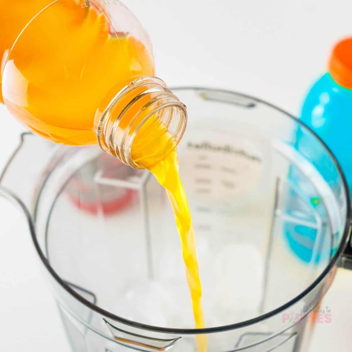 Pouring orange Gatorade into a blender.