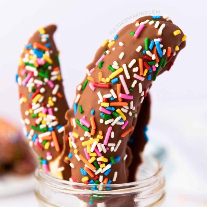 Chocolate covered banana pops displayed in a glass jar.