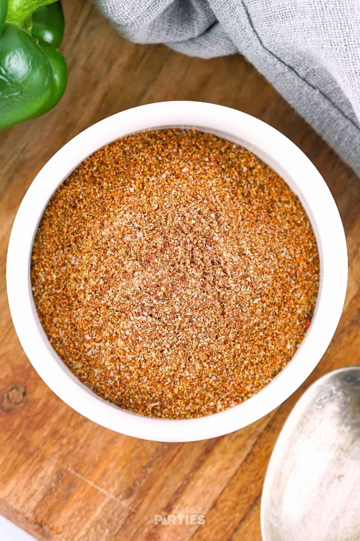 A white bowl filled with a mix of chili powder, Paprika, and other spices.