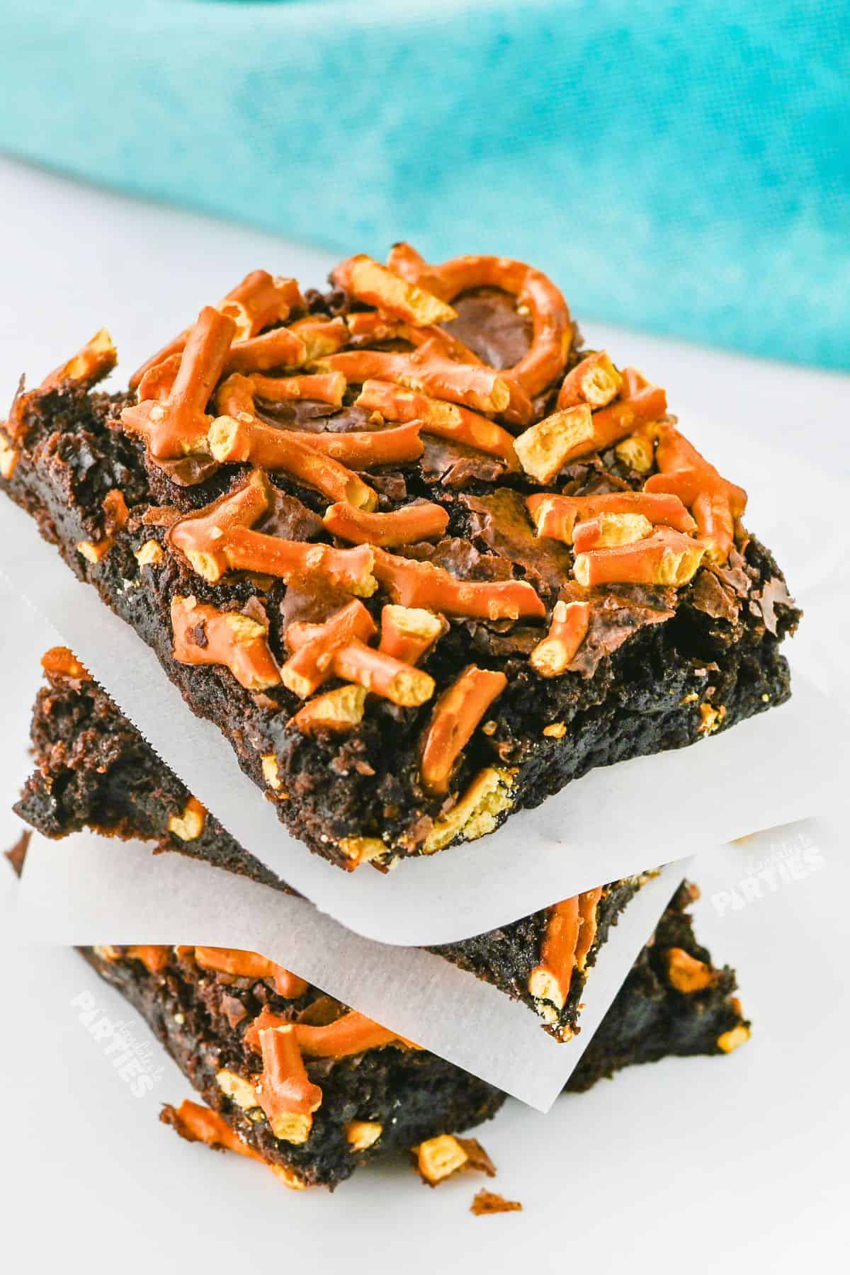 A stack of beer brownies with pretzel pieces.
