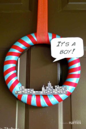 Superhero baby shower welcome wreath that says "It's a Boy".