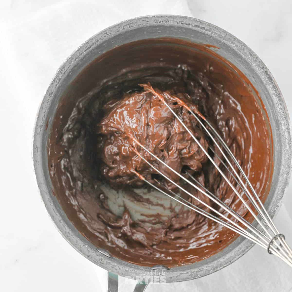 Adding chocolate chips to heated sugar water.