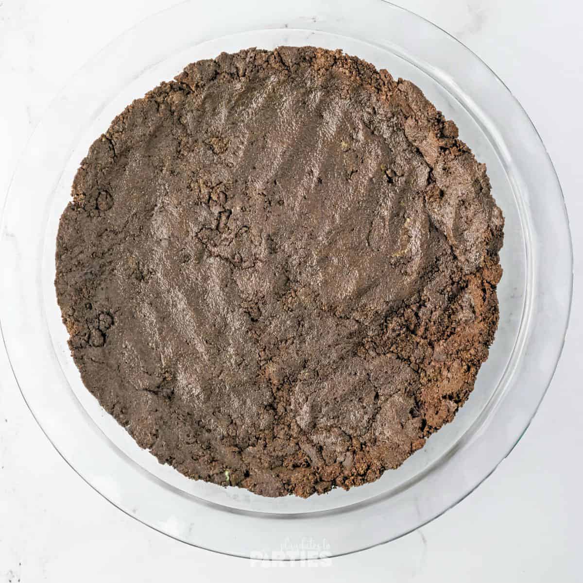 An Oreo cookie crust in a pie pan.