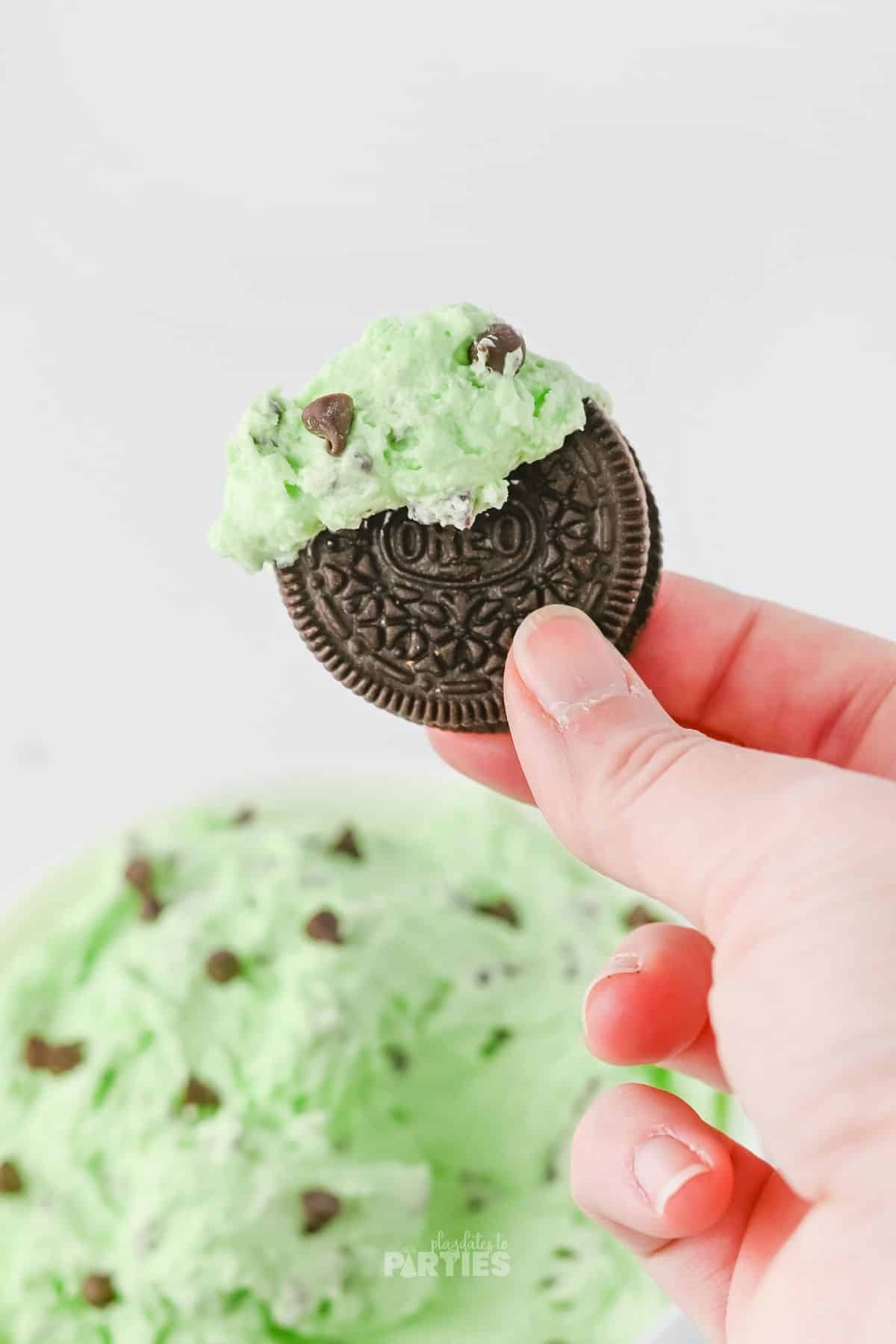 An Oreo cookie dipped in mint chip dip.