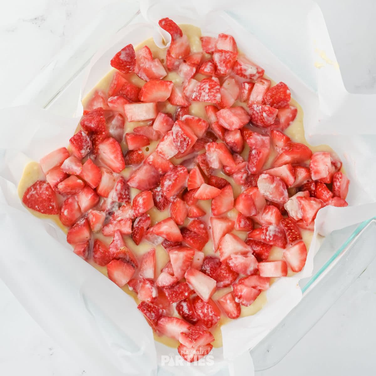 Mascerated strawberries layered on coffee cake batter.