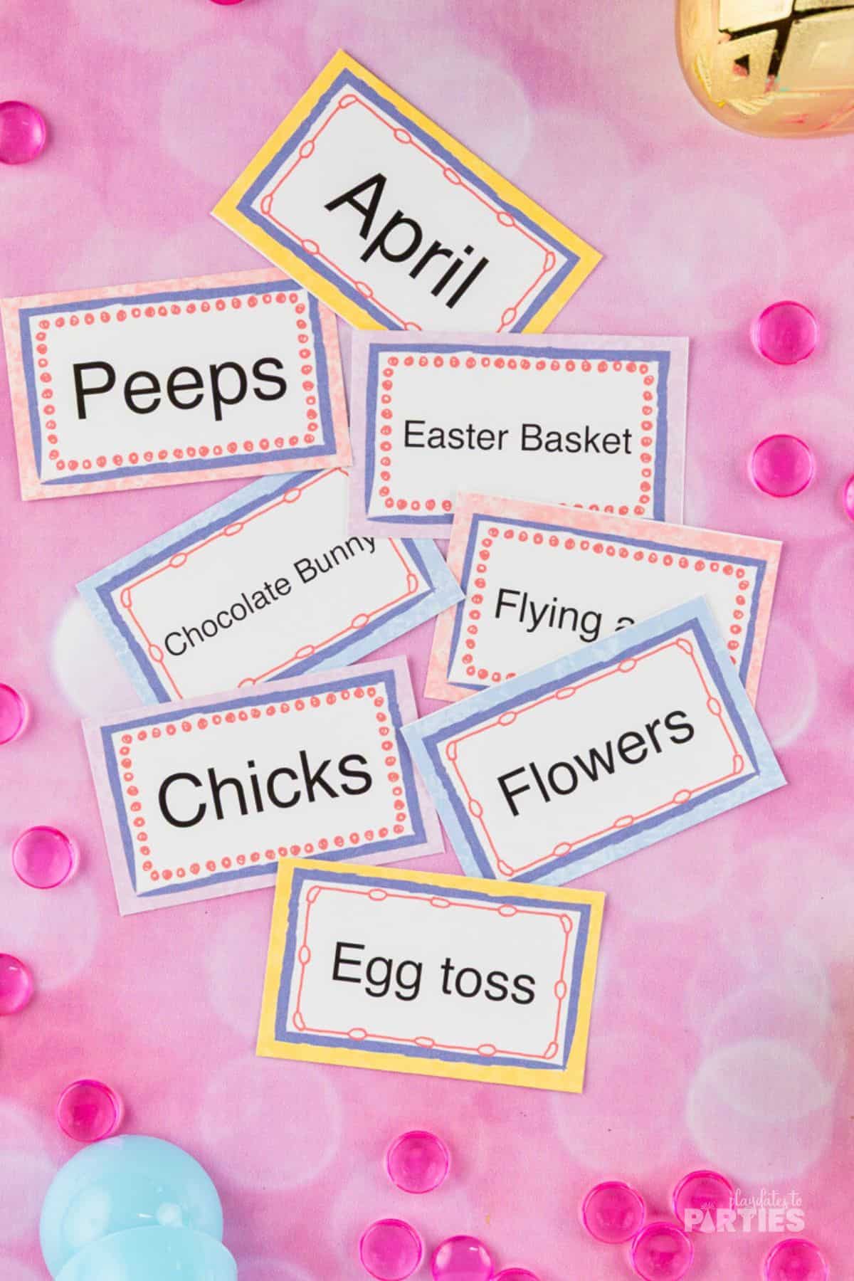 Printable Easter pictionary cards on a pink surface.
