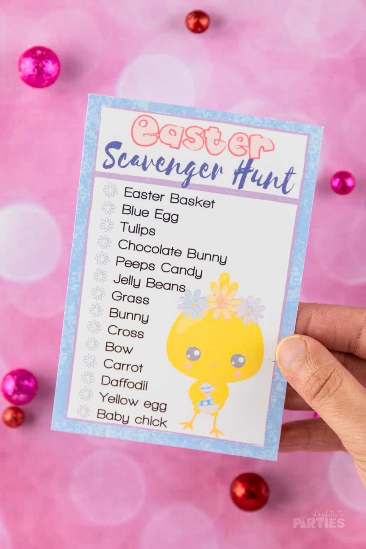 A woman's hand holding a text based scavenger hunt card for Easter.