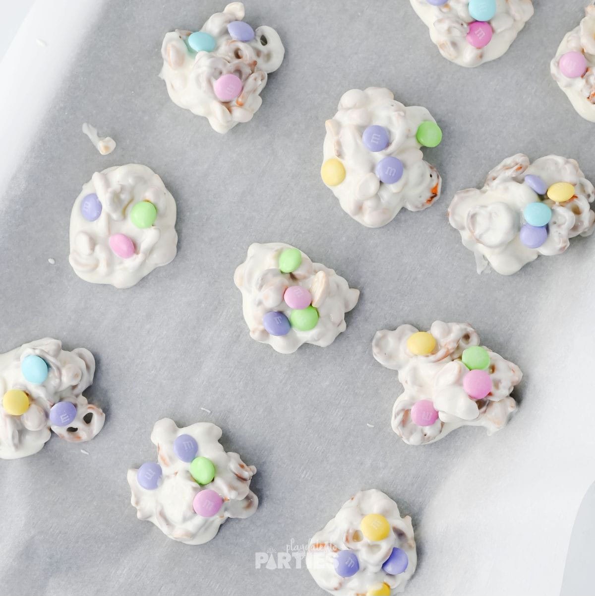 Candy clusters on a parchment lined baking sheet.