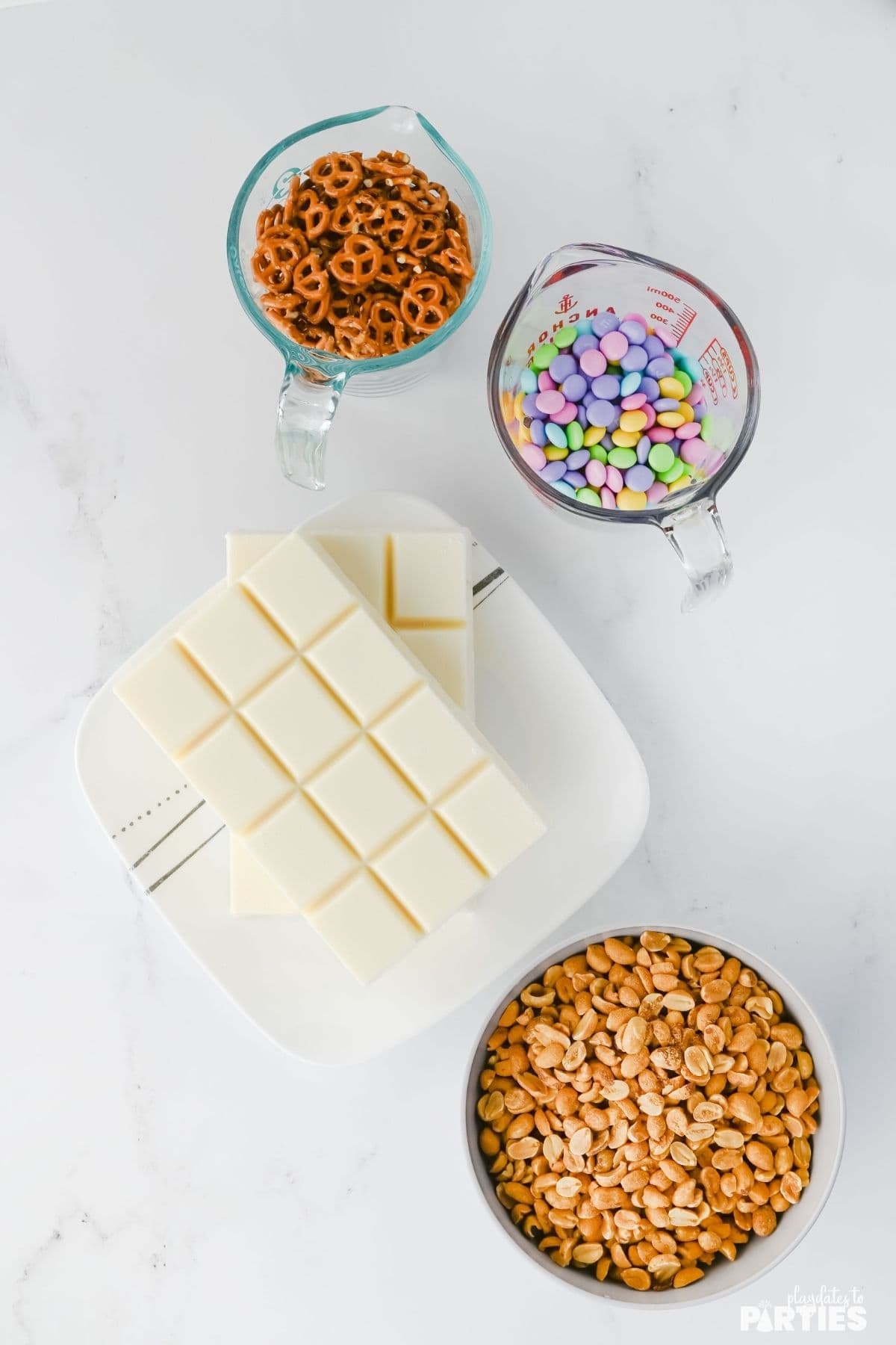 Ingredients include peanuts, pretzels, pastel candies, and white chocolate.