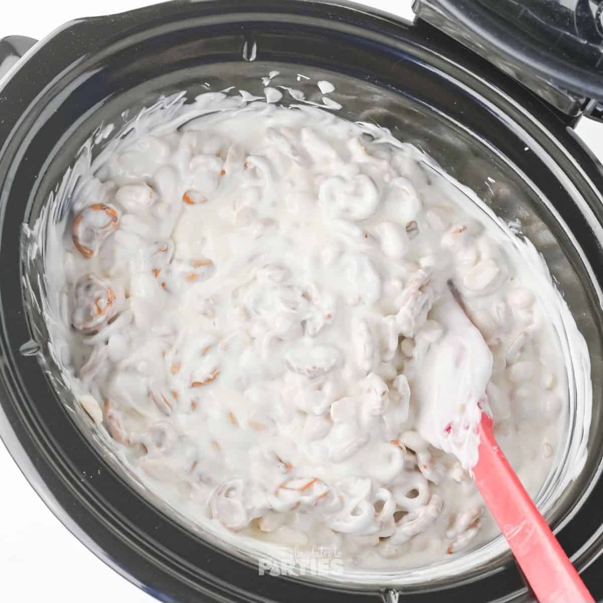 Peanuts and pretzels mixed into melted white chocolate.