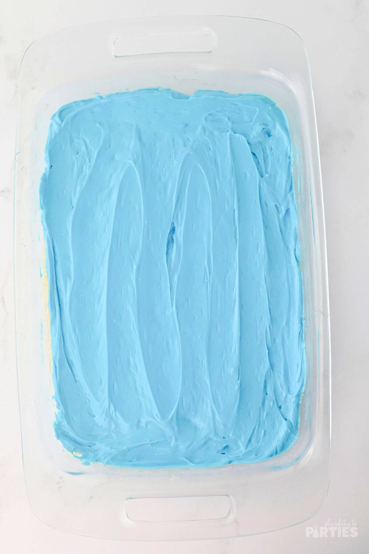 A blue cheesecake layer spread on the crust.