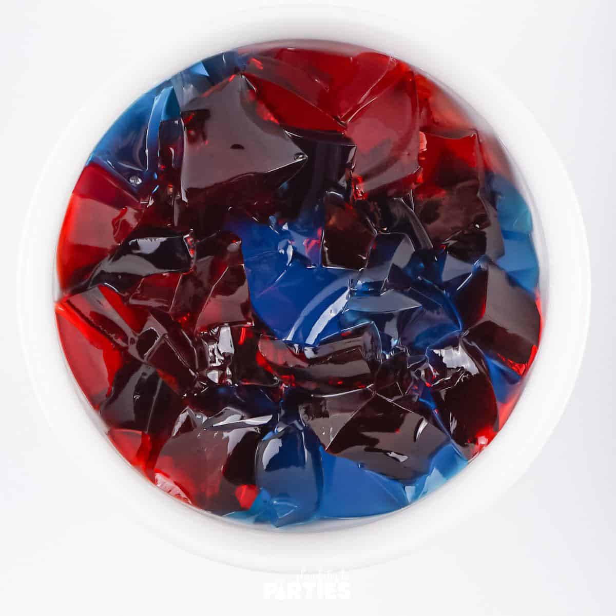 A bowl of blue and red jello pieces.