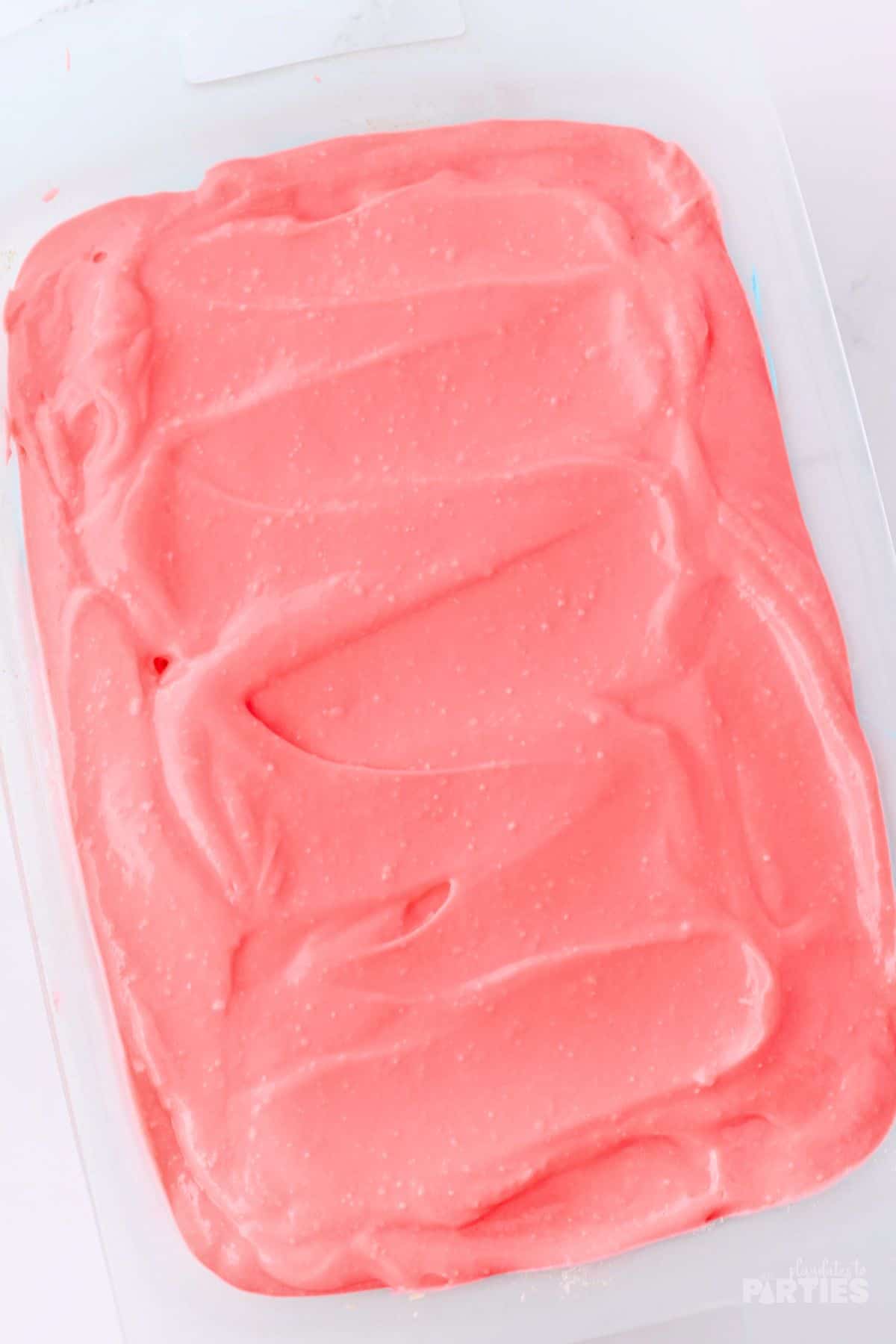 A red pudding cake layer spread on a cake.