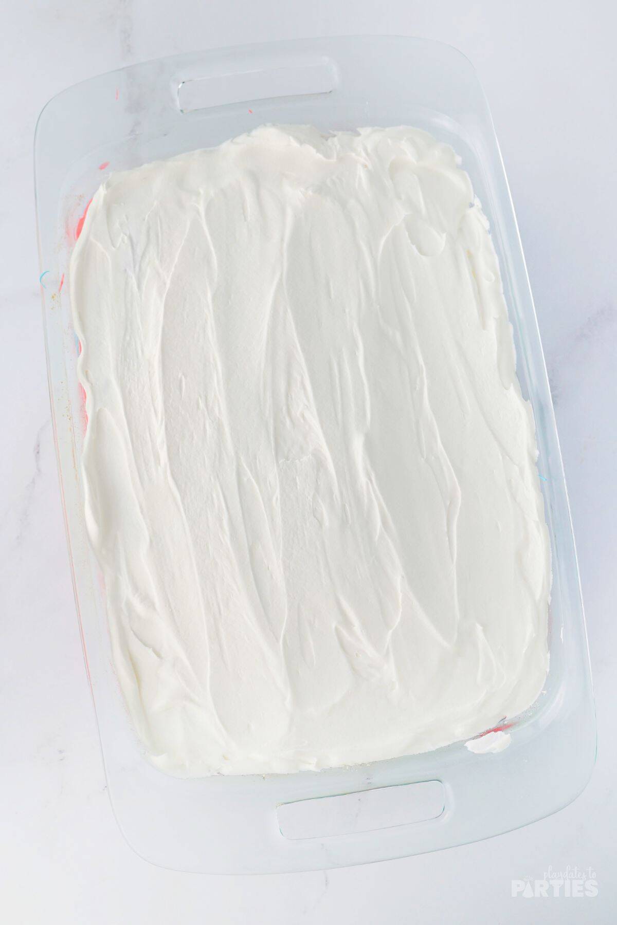 Cool whip spread on the top of a cake.