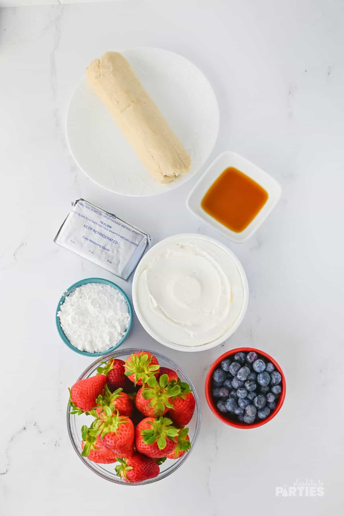 Ingredients include sugar cookie dough, cream cheese, fruit, powdered sugar, and Cool Whip.